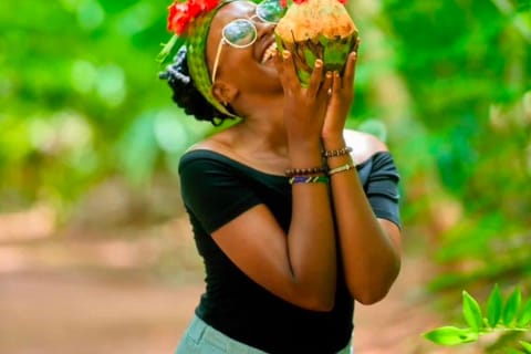 Happy guest sipping from a fresh Zanzibar coconut